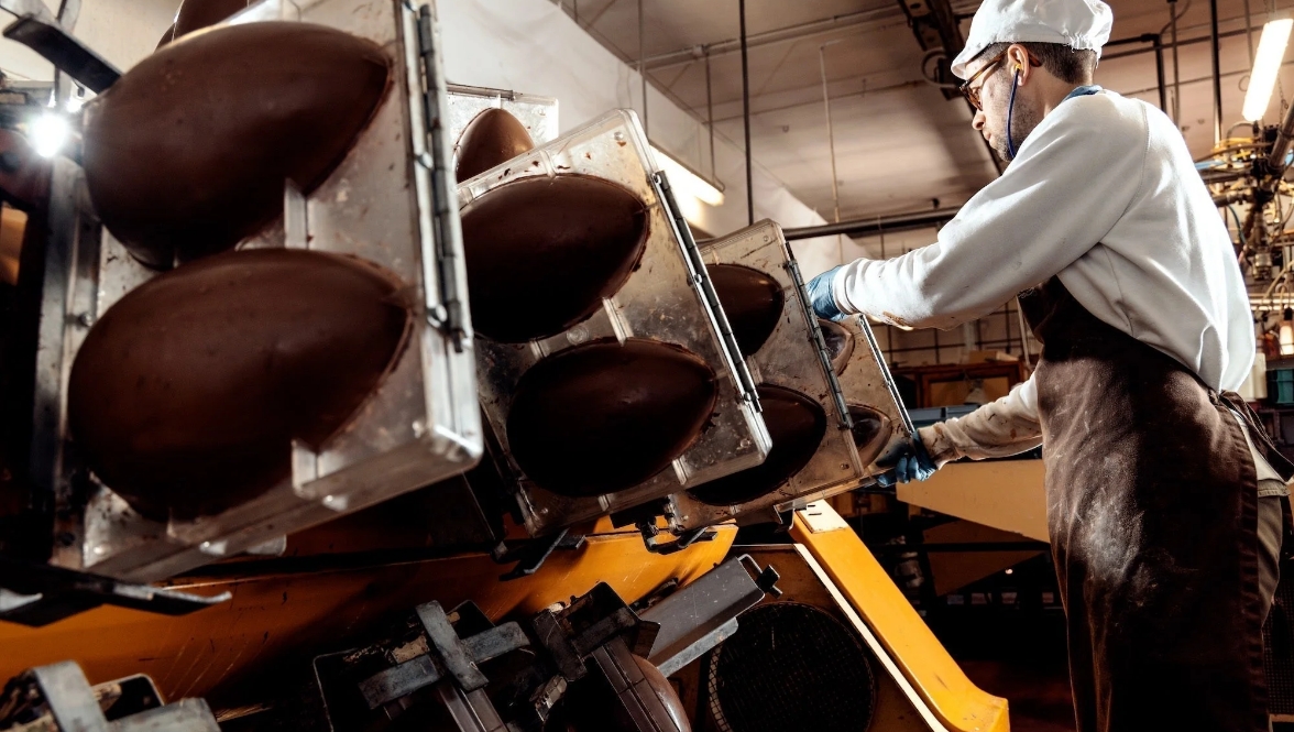 A man operating a chocolate producing machine